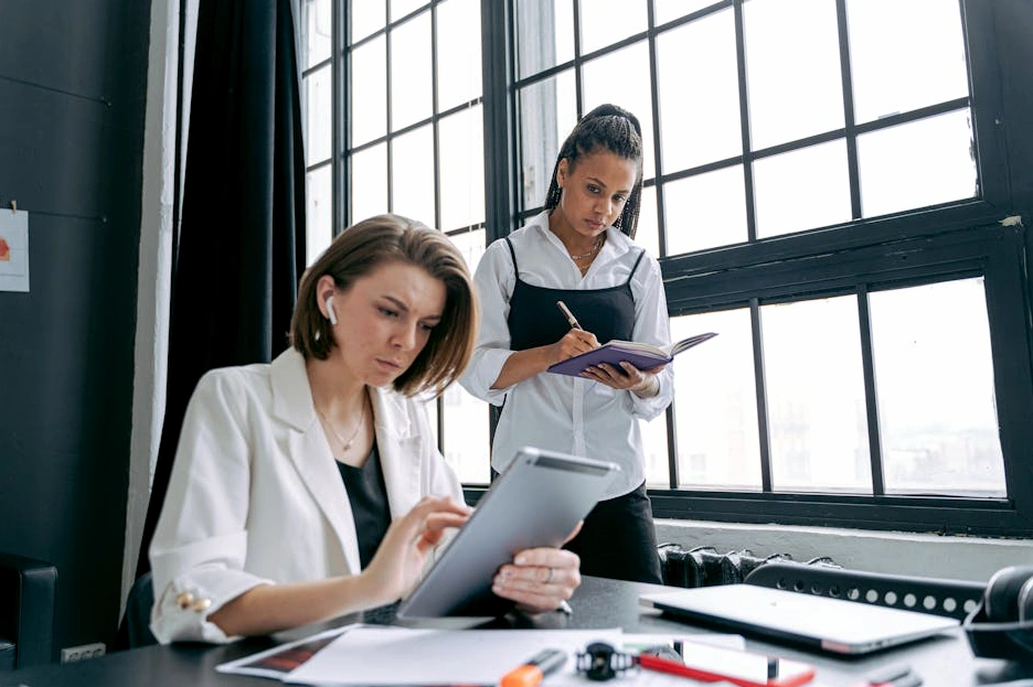 Persona che scrive su un taccuino durante una riunione di strategia.